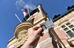 Photo d'une carte d'identité devant le Beffroi de l'Hôtel de Ville. 