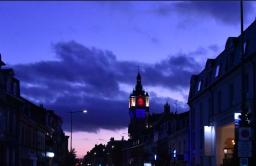 Photo du beffroi de nuit, éclairé en bleu, blanc et rouge.