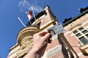 Photo d'une carte d'identité devant le Beffroi de l'Hôtel de Ville. 